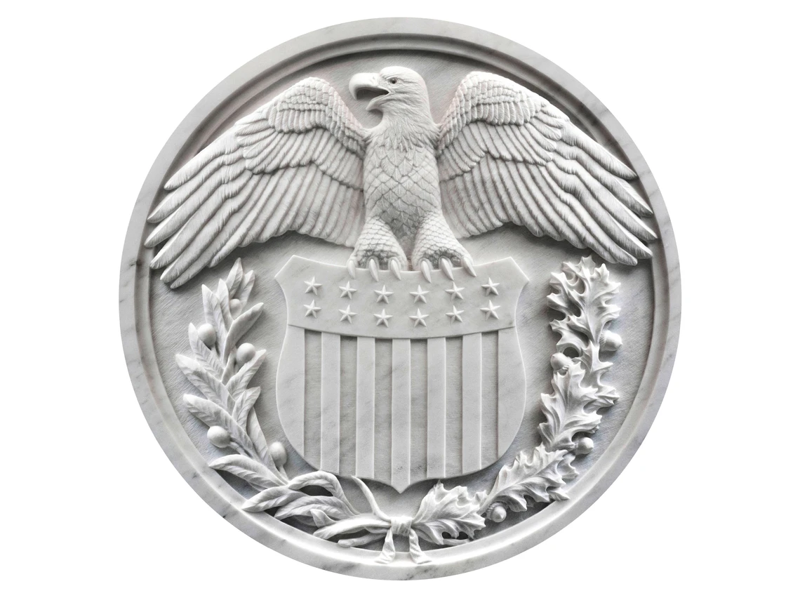 An image of a round sculpture of an eagle carved in stone.